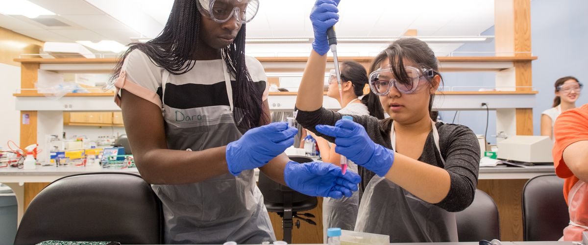 Lab partners Oluwadara Okeremi, 16, of Nigeria, left, and Kristin Nguyen, 17, of CA work together through a plasmid mini prep kit July 27, 2017, during their RISE Practicum in Molecular Biology. Photo by Cydney Scott for Boston University