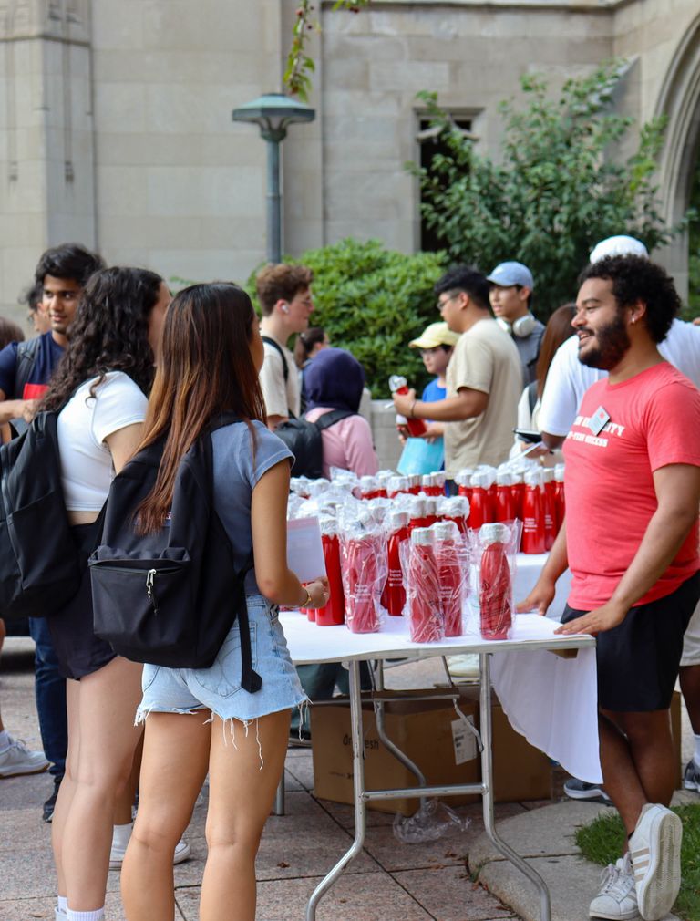 An Assistant Director for First-Year Success speaks with students at a campus event.