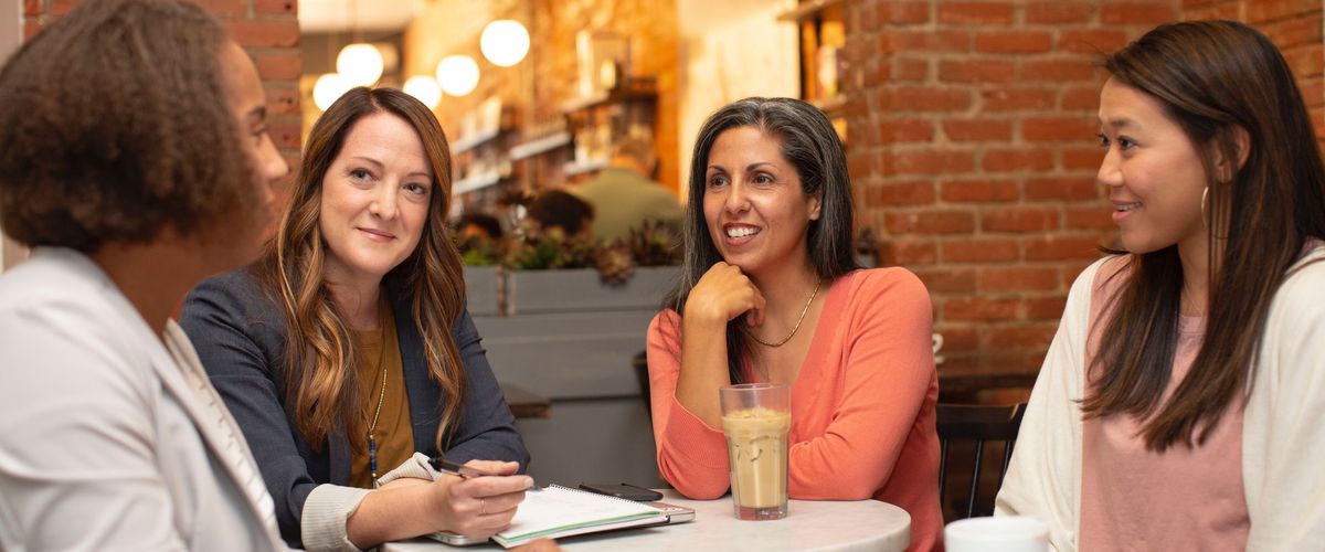 Four women working in a business meeting in a cafe coffee shop