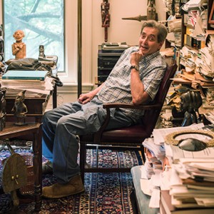 Stephen Grossberg, sitting in a chair in his home in Newton