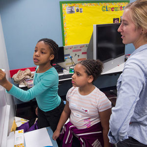 Aurora Kesseli with third-graders Amaria Smith (left) and Cassandra Riley as they work on an experiment at the Girls Science Club.