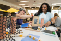 Preschool teachers Jill Olive (left) and Kim Haywood try out some of the creative activities the Reggio Emilia approach offers children.