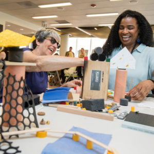 Preschool teachers Jill Olive (left) and Kim Haywood try out some of the creative activities the Reggio Emilia approach offers children.