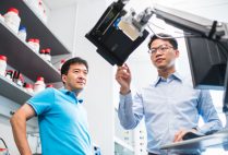 BU biomedical engineers Ji-Xin Cheng (left) and Lu Lan (right) monitor a tablet that displays AcouStar guidance to surgeons.