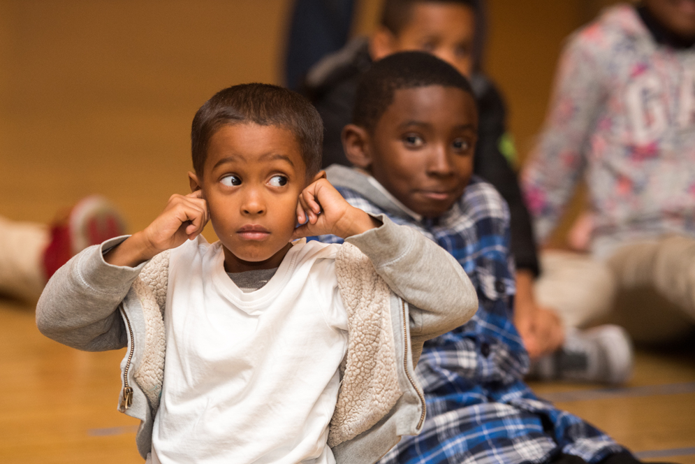 A kid covers his ears during the After-School Music program