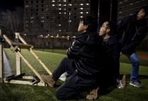 Kai Hui and Tai Kang launch their catapult with the help of Lei (Ray) Shi during the College of Engineering's Tinker Catapult Challenge launch day.