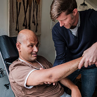 Craig Cloutier helps exercise Rahul Desikan's arm.