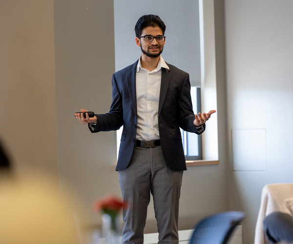 BU student in a suit giving a presentation