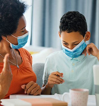 Woman & child wearing facemasks and discussing the COVID pandemic