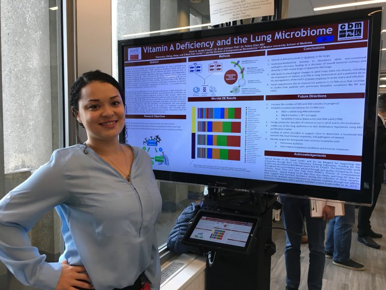 Photo of student in front of digital board displaying data science research