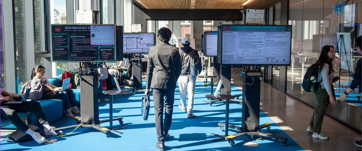 Photo of students and digital boards displaying data research in the BU Spark! Space