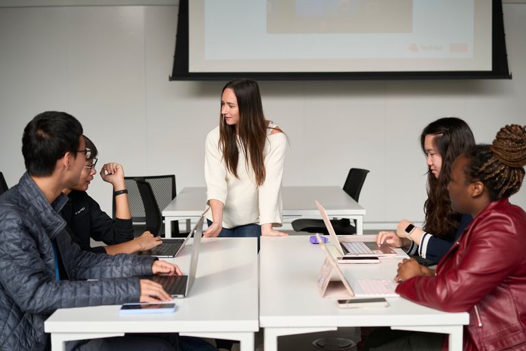 Photo of 4 students and a teaching assistant collaborating in class