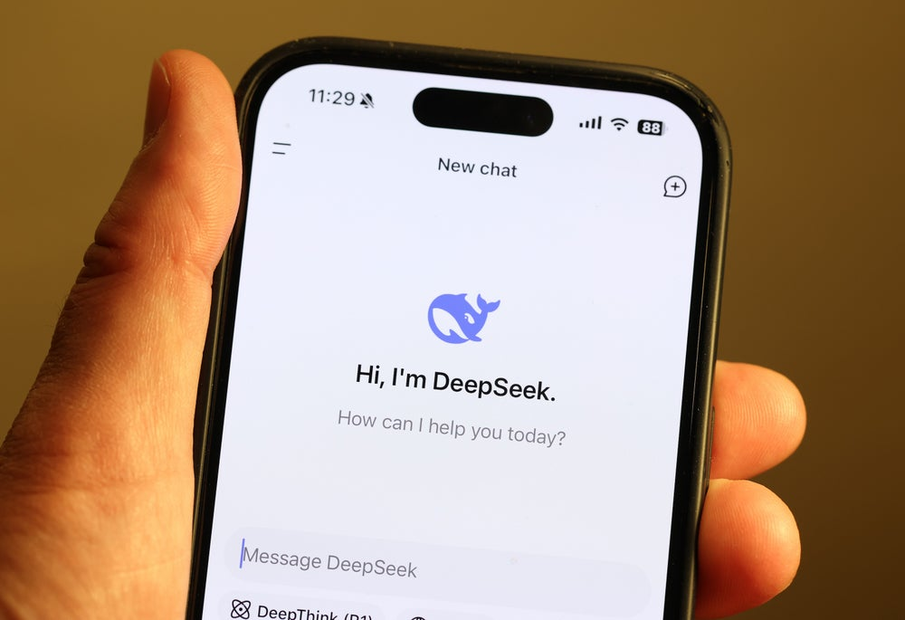 Photo of a hand holding an iPhone displaying a screen showing Deepseek AI interface