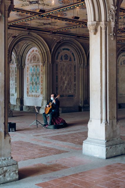 man playing guitar wearing a mask