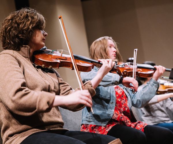 Music student playing the violin at concert