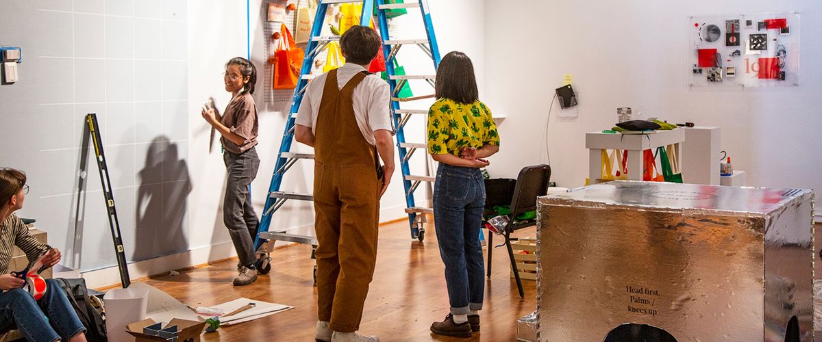 visual arts undergraduate students installing artwork in a gallery