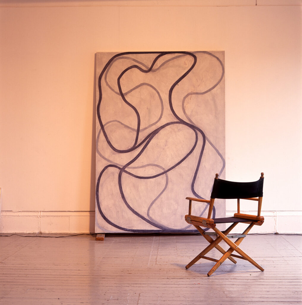 Marden’s New York studio, photographed in 1998. Photo captures a painting and a chair facing the painting.