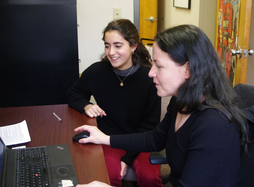 Joelle Renstrom and Sofia Zalaquett looking at videos for their research