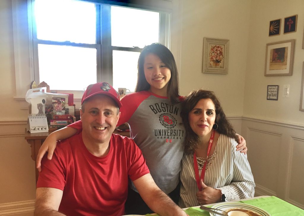 Natalie Seara with her arms around her parents