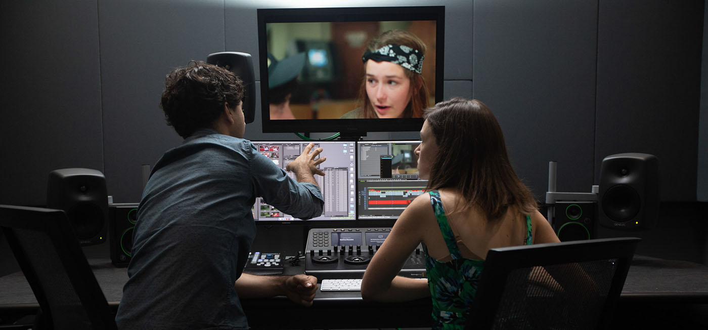 Man and woman reviewing video in an editing bay.