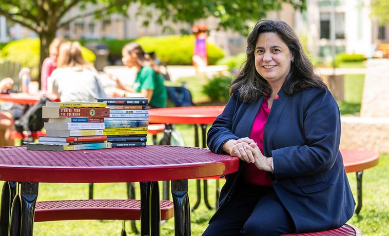 COM Dean Mariette DiChristina seated at table on COM Lawn.