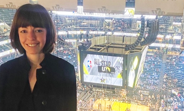 Caroline Klein posing in the rafters above a basketball court.