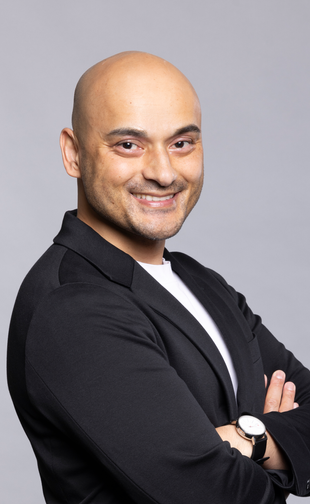 Ned standing crossed arms headshot with gray background