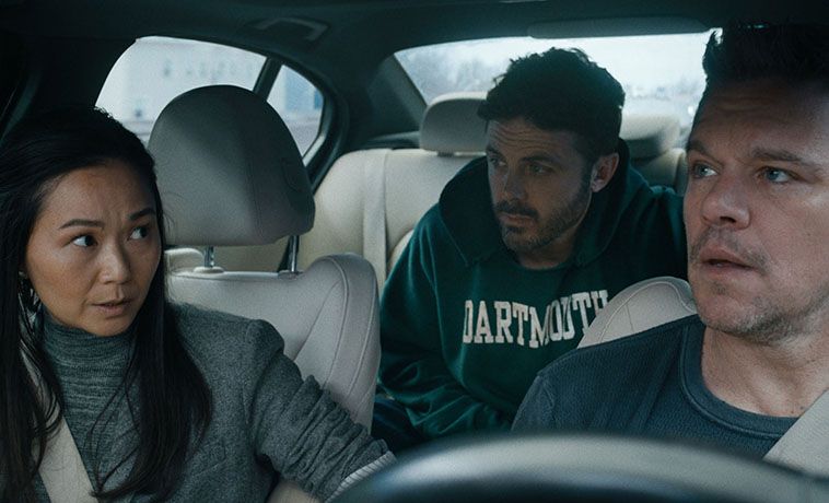 Hong Chao sits in the front seat of a car with Matt Damon and Casey Affleck in a scene from the film The Instigators.