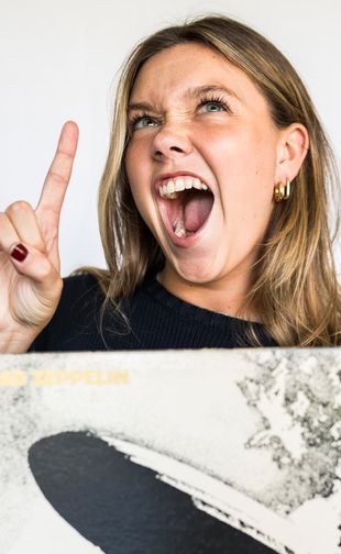 Headshot holding a record and rock on hand gesture