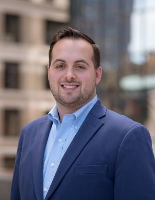 City headshot wearing blue blazer