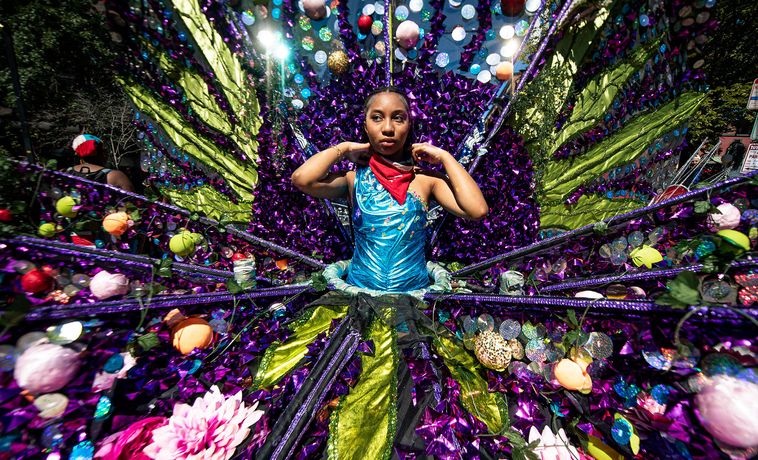 Girl wearing ornate and multicolored dress.