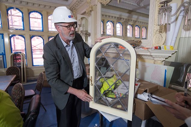 Meissner holds up a window. All windows in the Castle are undergoing restoration.