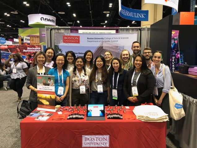 BUCS students and staff members pose at the BU booth.