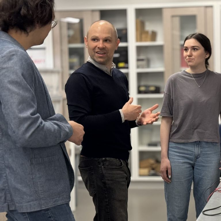Two people standing in a lab, to test some hardware they create to study human brain functions