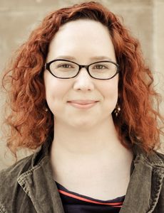 Image of female with glasses with medium length curly red hair. 