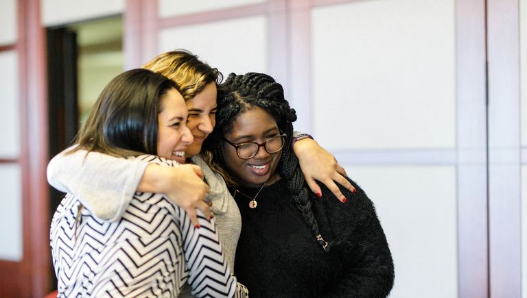 Three women hugging one another
