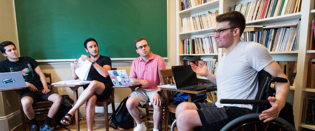 Man in a wheelchair collaborating with other students