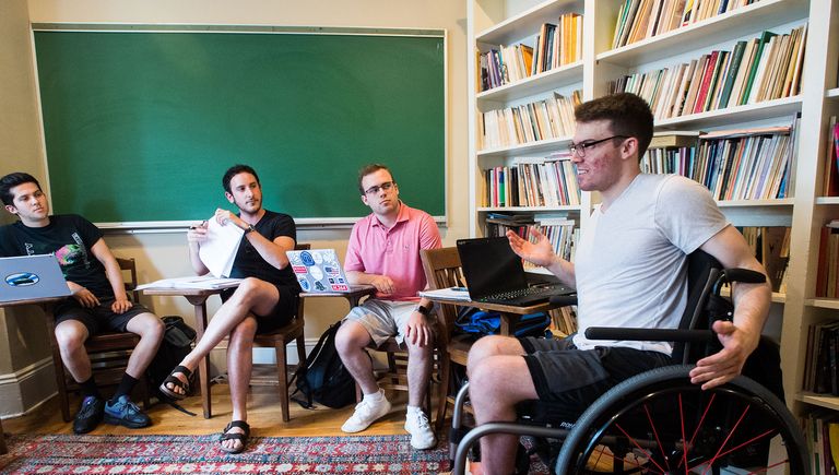 Man in a wheelchair collaborating with other students