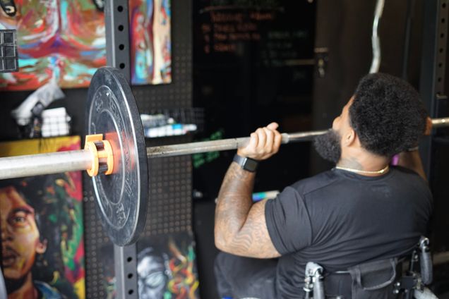Black man in a wheelchair lifting weights