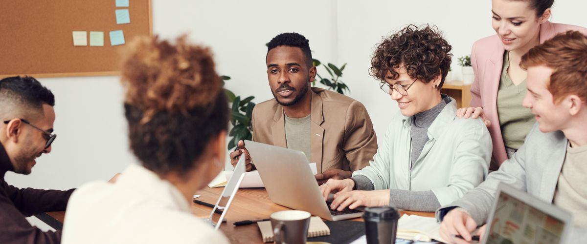 Group of six people discussing in an work environment