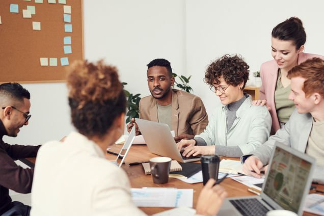 Group of six people discussing in an work environment