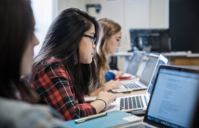 3 students working on computers sitting in a row
