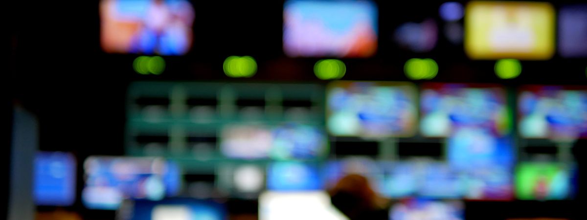 A blurry image of a room filled with TV monitors