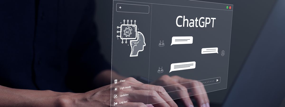 Hands typing on a laptop with the ChatGPT logo in a chat box above the keyboard