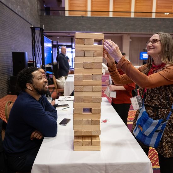 An attendee is playing Big Jenga at a table