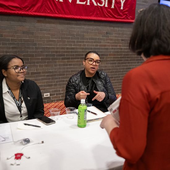 An attendee is chatting with people at a table