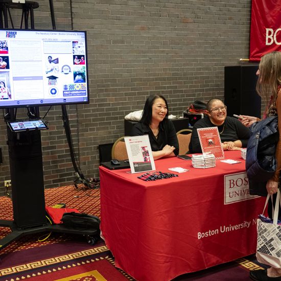 An attendee visits a poster session table