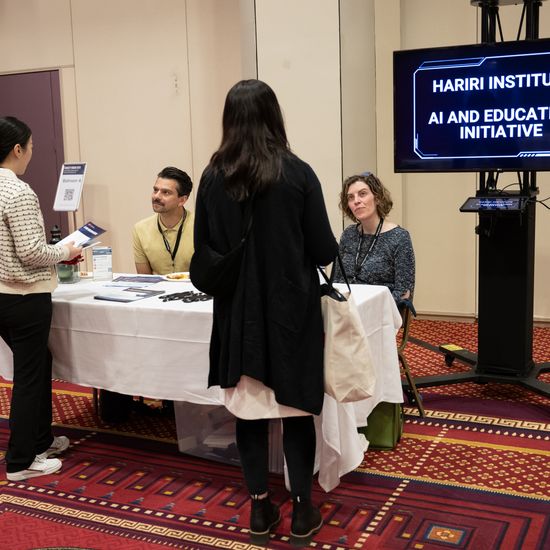 Attendees visit the Hariri Institute poster session table.