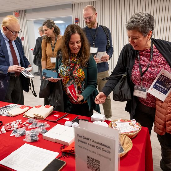 Attendees grab DL&I swag before heading into the Faculty Forum 2024