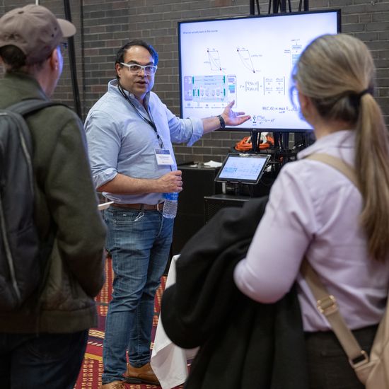 Attendees gather in front of an e-poster session.